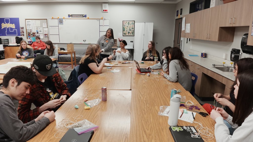 students learning to weave