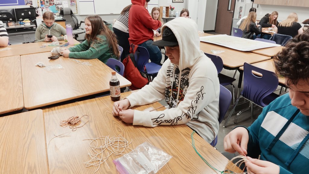 students learning to weave