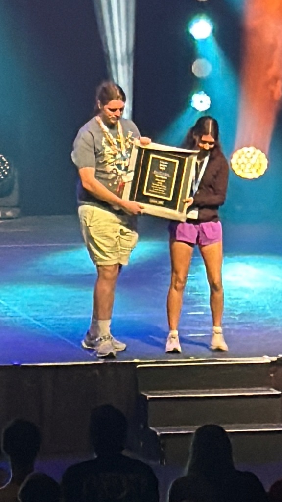 students on stage with a trophy