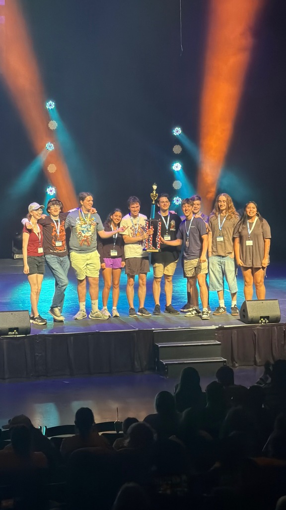 students on stage with a trophy