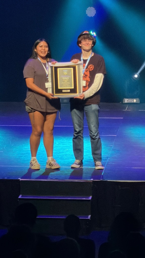 students on stage with a trophy