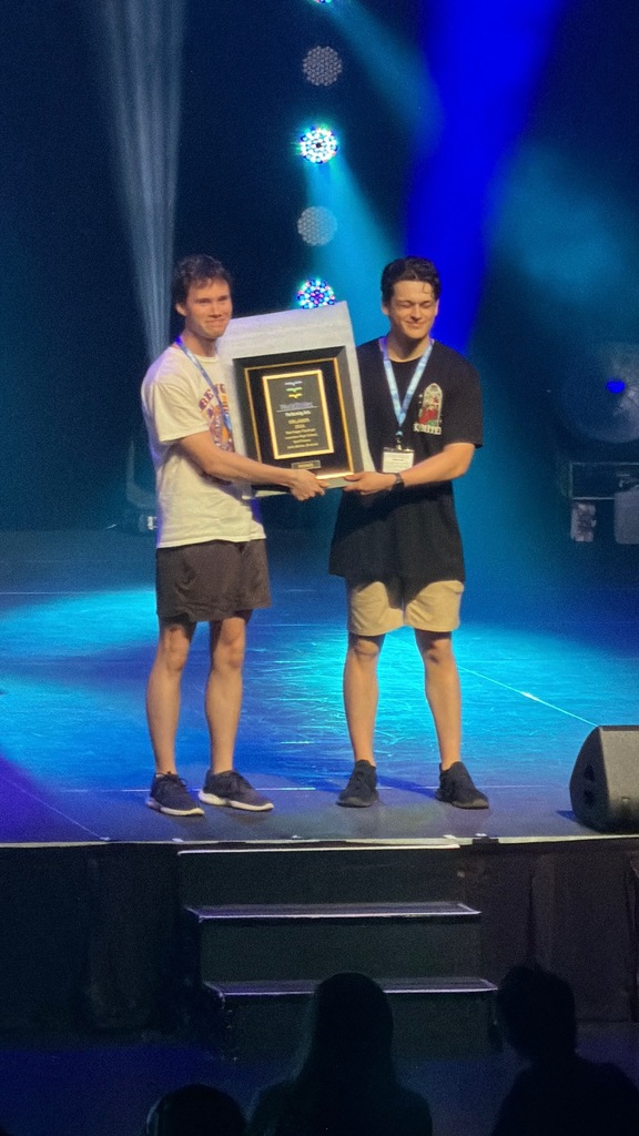 students on stage with a trophy