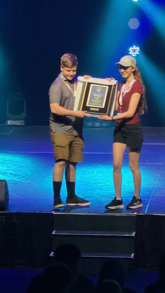 students on stage with a trophy