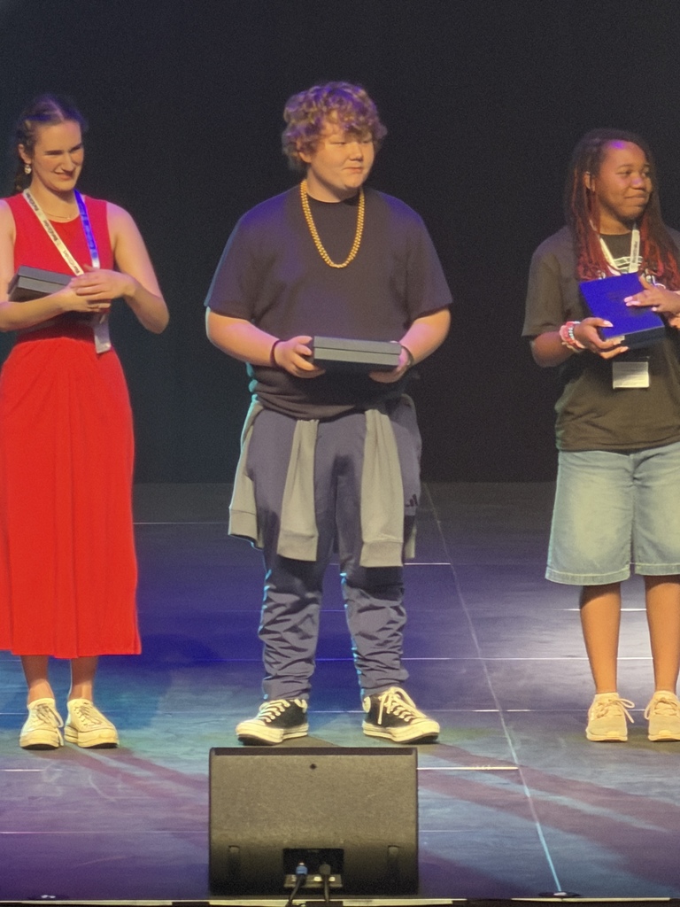 students on stage with a trophy