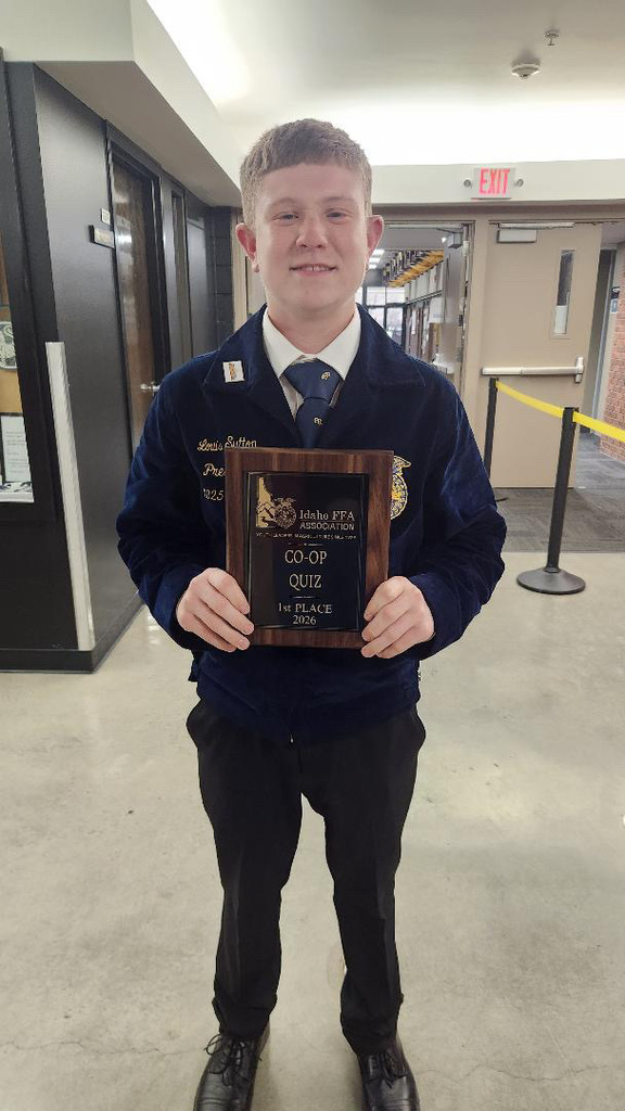 student in FFA jacket holding a trophy