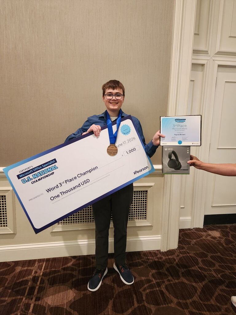student holding a giant check