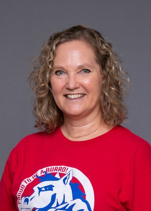 woman with mid length blonde curly hair and a red shirt