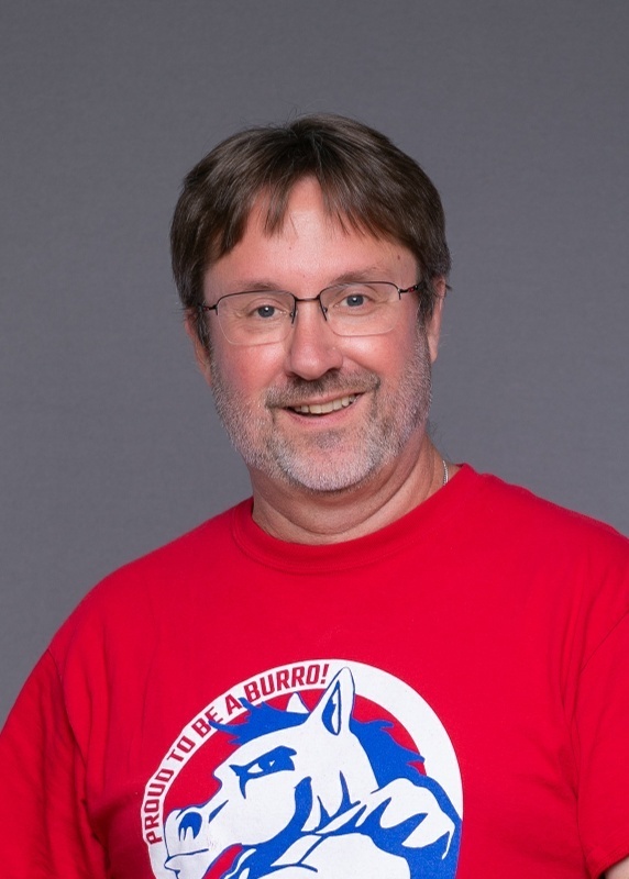 man with brown hair and glasses, wearing a red shirt