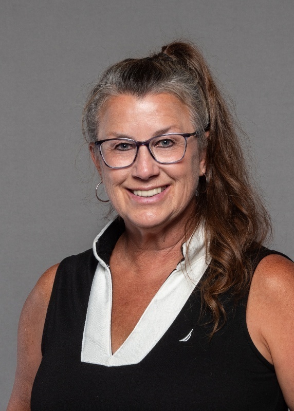 Laura has glasses, a brunette ponytail, black poly, with a white collar