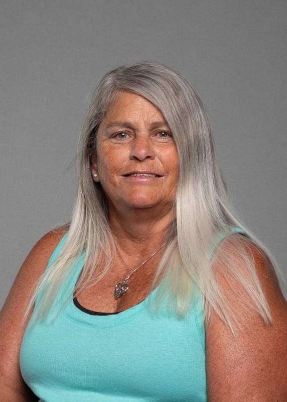 woman with long blonde hair and a blue tank top on