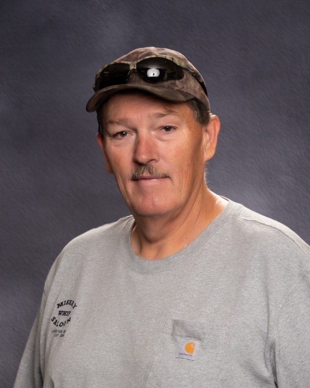 man in ball cap and grey shirt