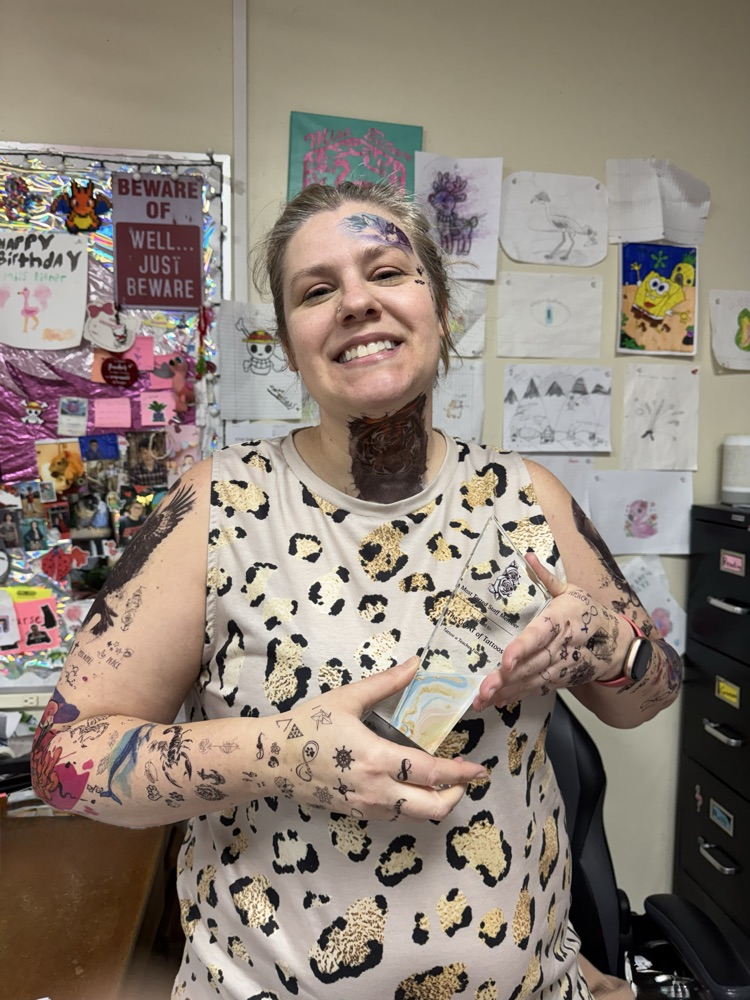 person with temporary tattoos and a trophy