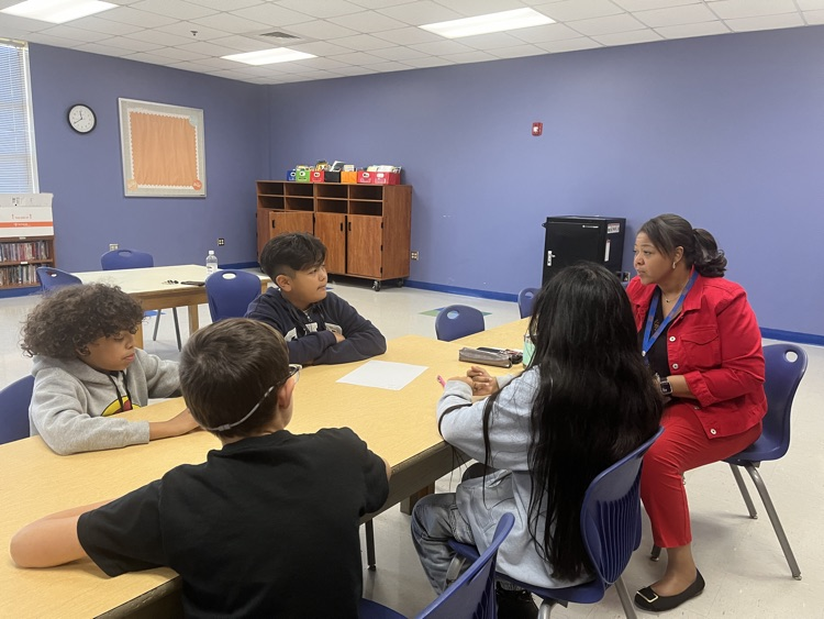 Dr. Hardy seated at a  table with Charles England Elementary students during the first Student Advisory meeting of the school year.