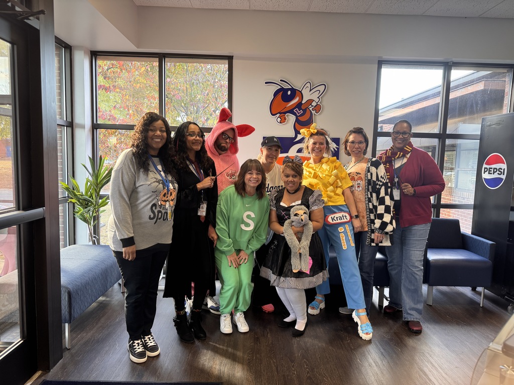 Central Office staff dressed in costumes smiling and celebrating the final day of FA-BOO-LOUS Week.