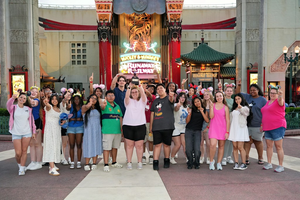 Group of Lexington City Schools chorus students posing together during their trip to Walt Disney World, celebrating their Best in Class award and Superior rating at a choral competition.