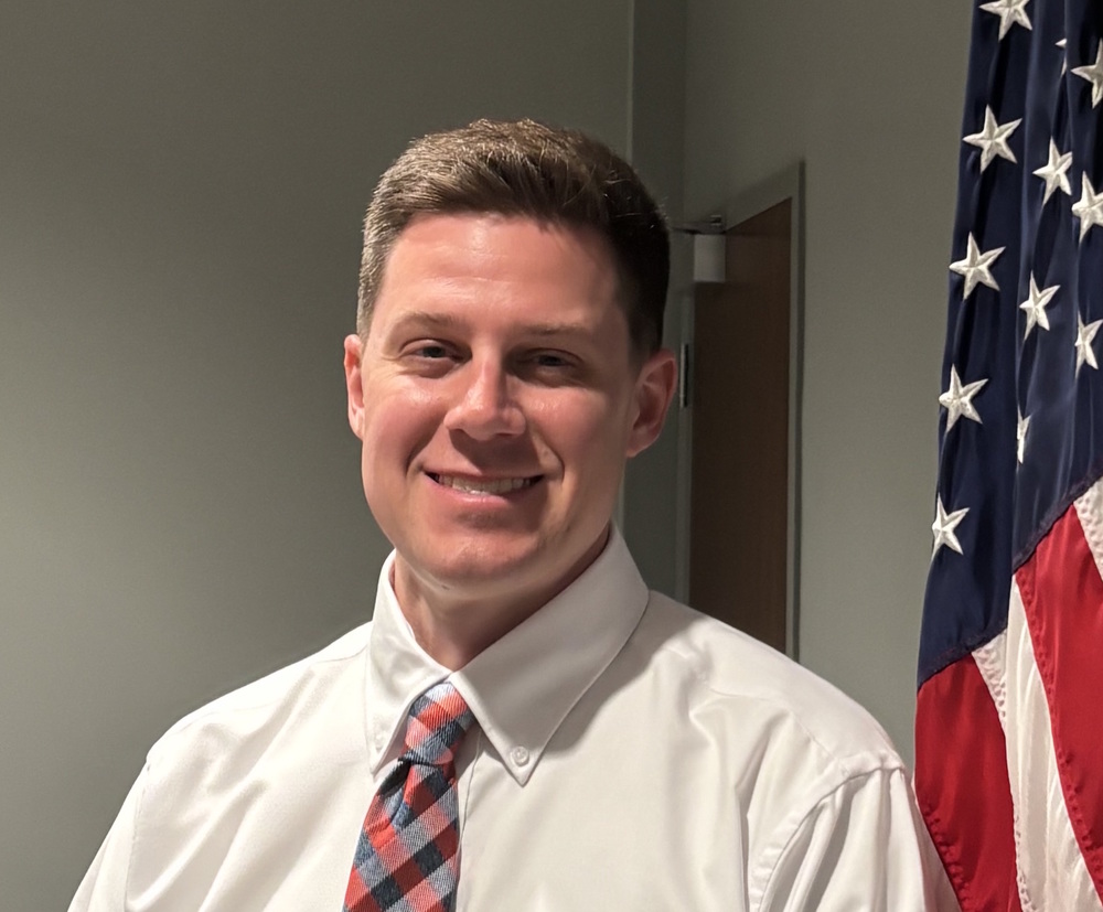 Andrew Price standing next to US flag