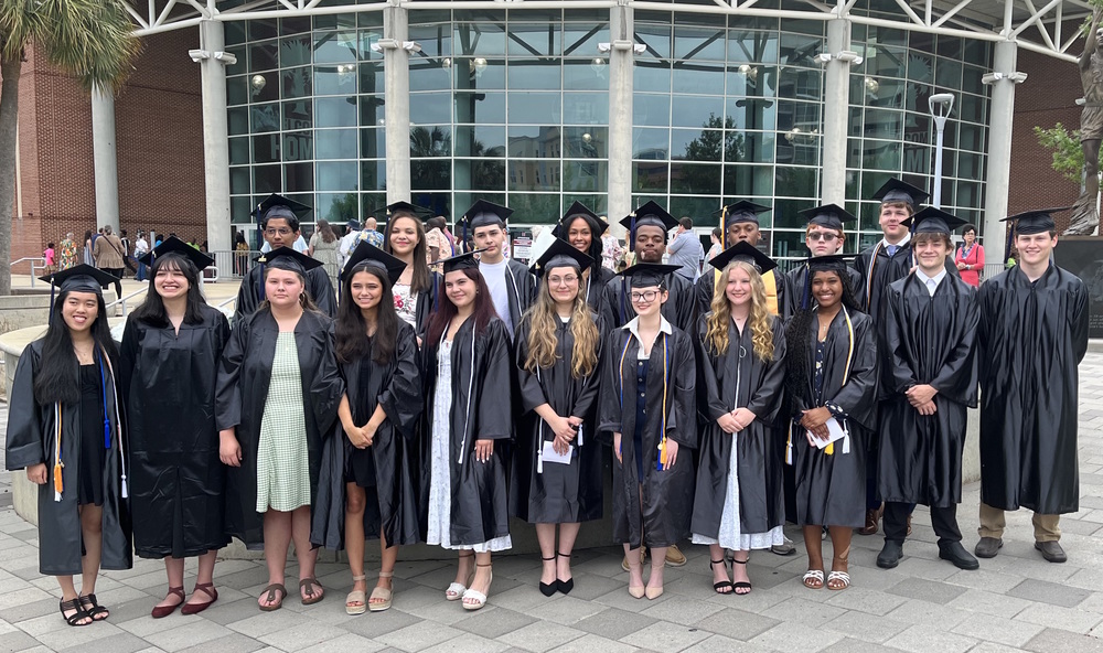 Lex2 students invited to walk at Midlands Tech graduation pose in front of Colonial Life Arena