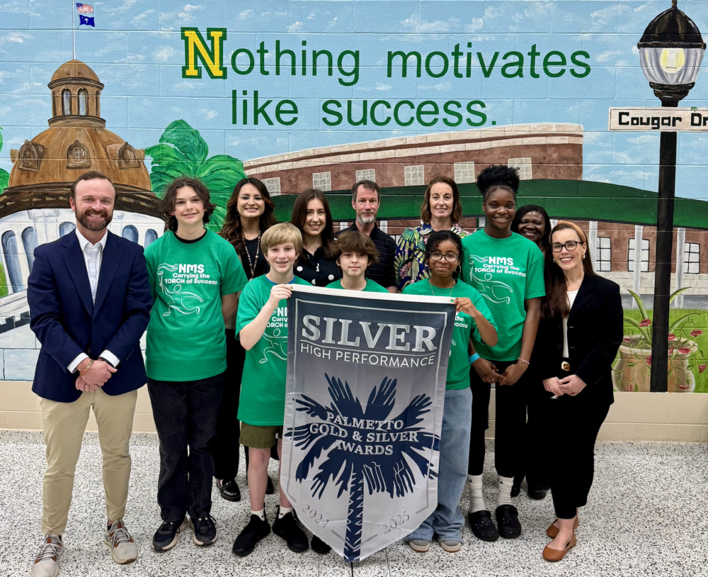 Northside administrators, teachers and students with the Palmetto Silver banner