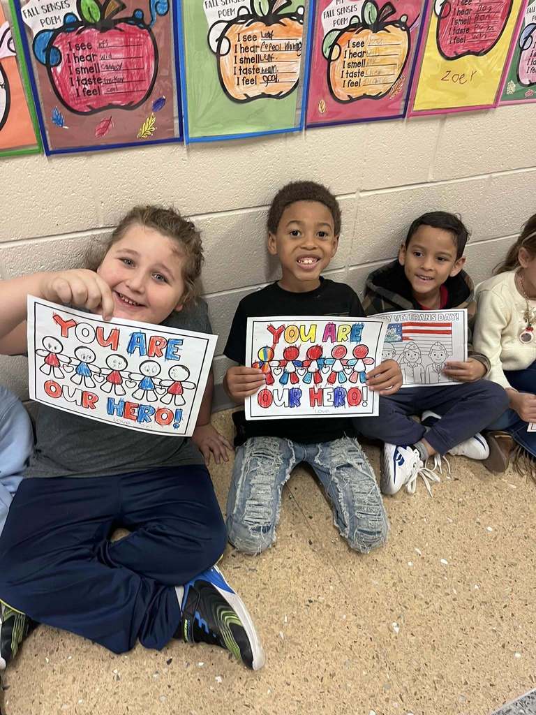Kids holding sign for Veteran's Day