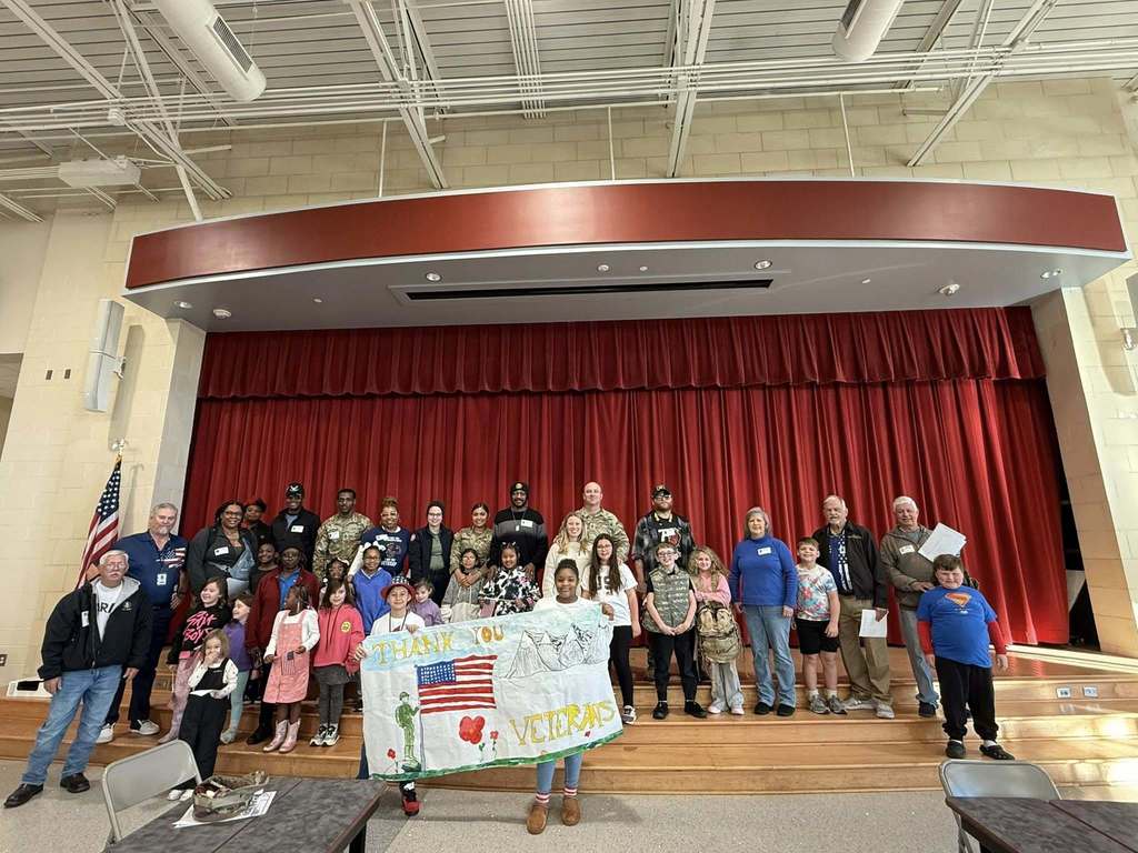 Kids holding sign for Veteran's Day