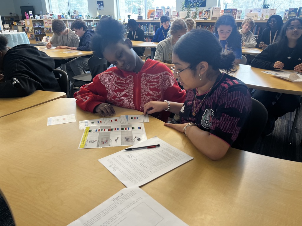 Two students investigate DNA samples from a forensics lab for a pretend crime scene.