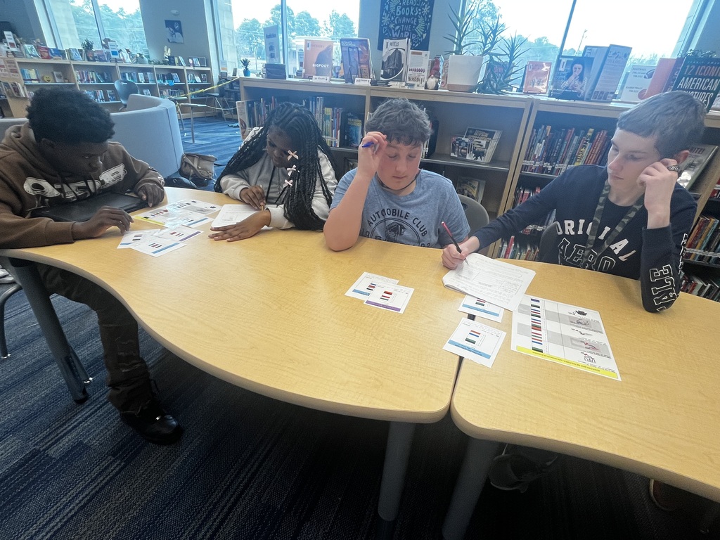 Two students investigate DNA samples from a forensics lab for a pretend crime scene.