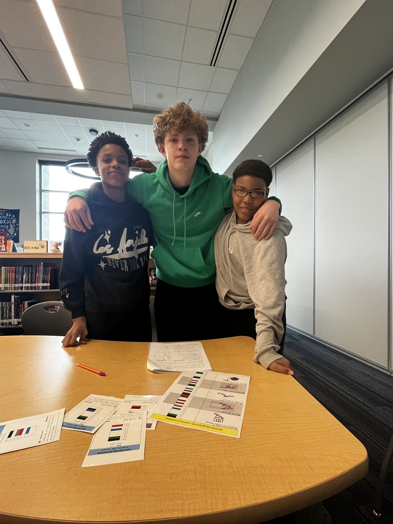 Three students smile for the camera after investigating and correctly identifying the criminal in the pretend crime scene investigation.
