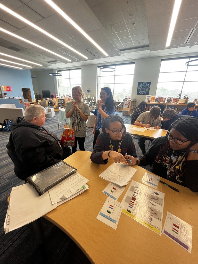 Two students investigate DNA samples from a forensics lab for a pretend crime scene. Other students who identified the correct criminal and provided substantial evidence to support their claims received a lollipop from their science teacher.