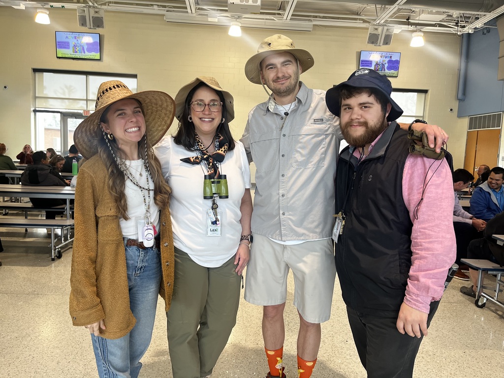 Four teachers msiling for the camera wearing Explorer and Adventurer attire.