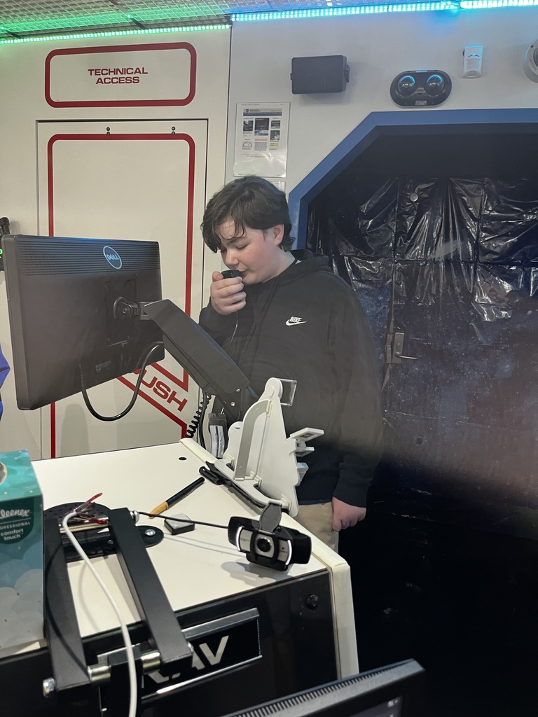 Student speaks into a radio giving directions to the test control center in the next room.