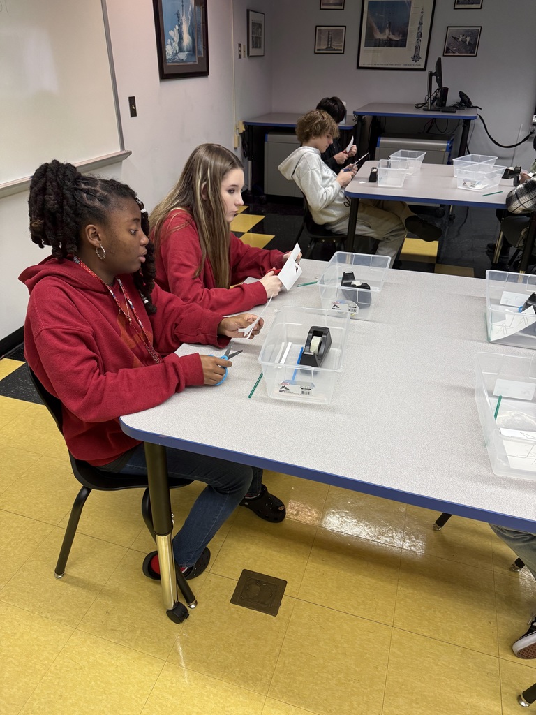 Two female students are building their paper straw rockets.
