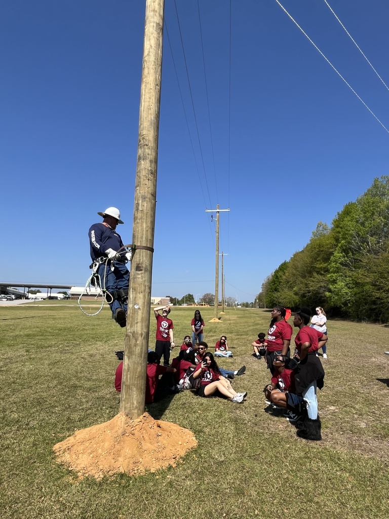 A man demonstrating climbing up a power line.