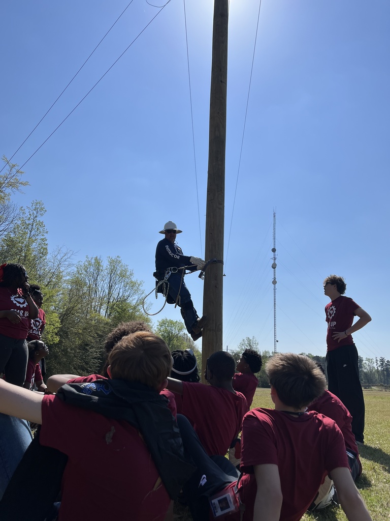 A man demonstrating climbing up a power line.