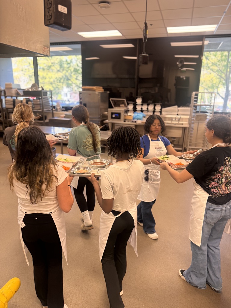 Students walking with their food preps to their cooking stations.