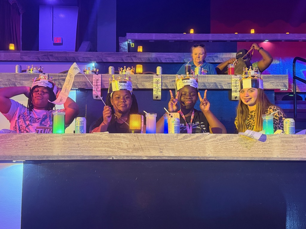 Students seated at tables waiting for the Medieval Times Show to begin.