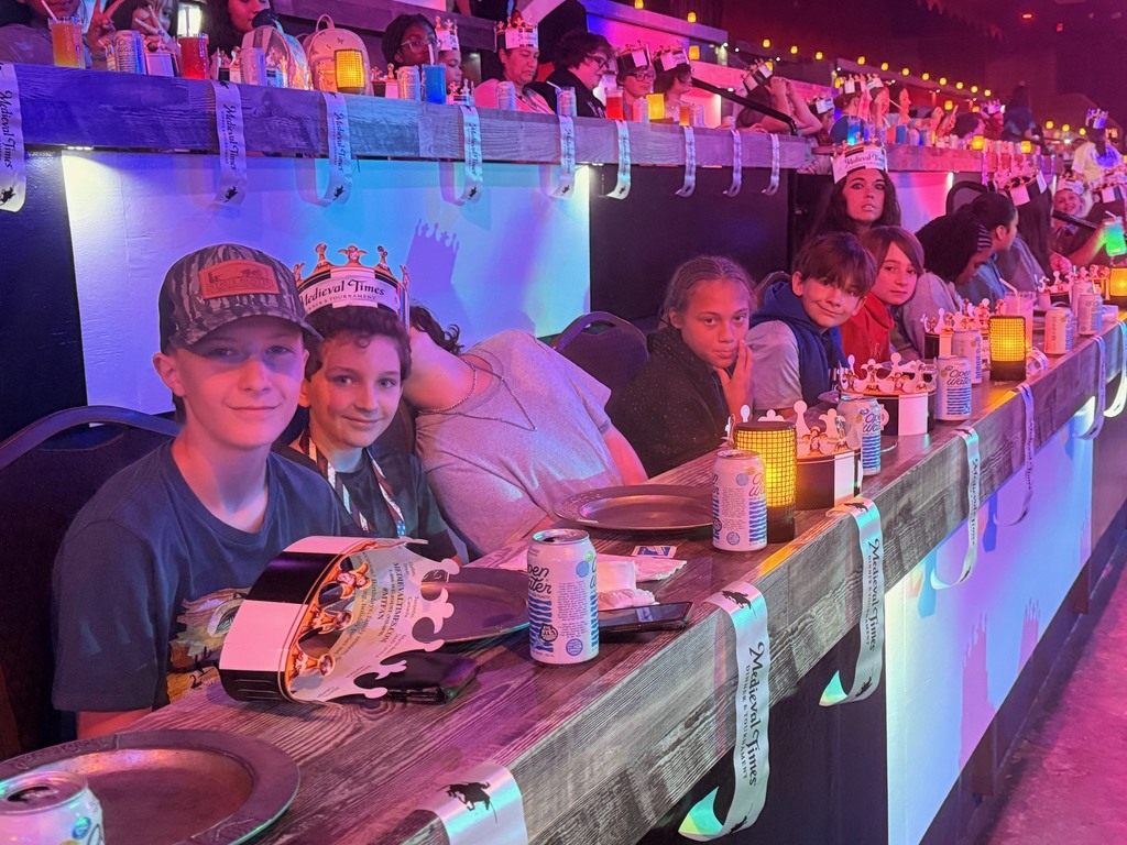 Students seated at tables waiting for the Medieval Times Show to begin.