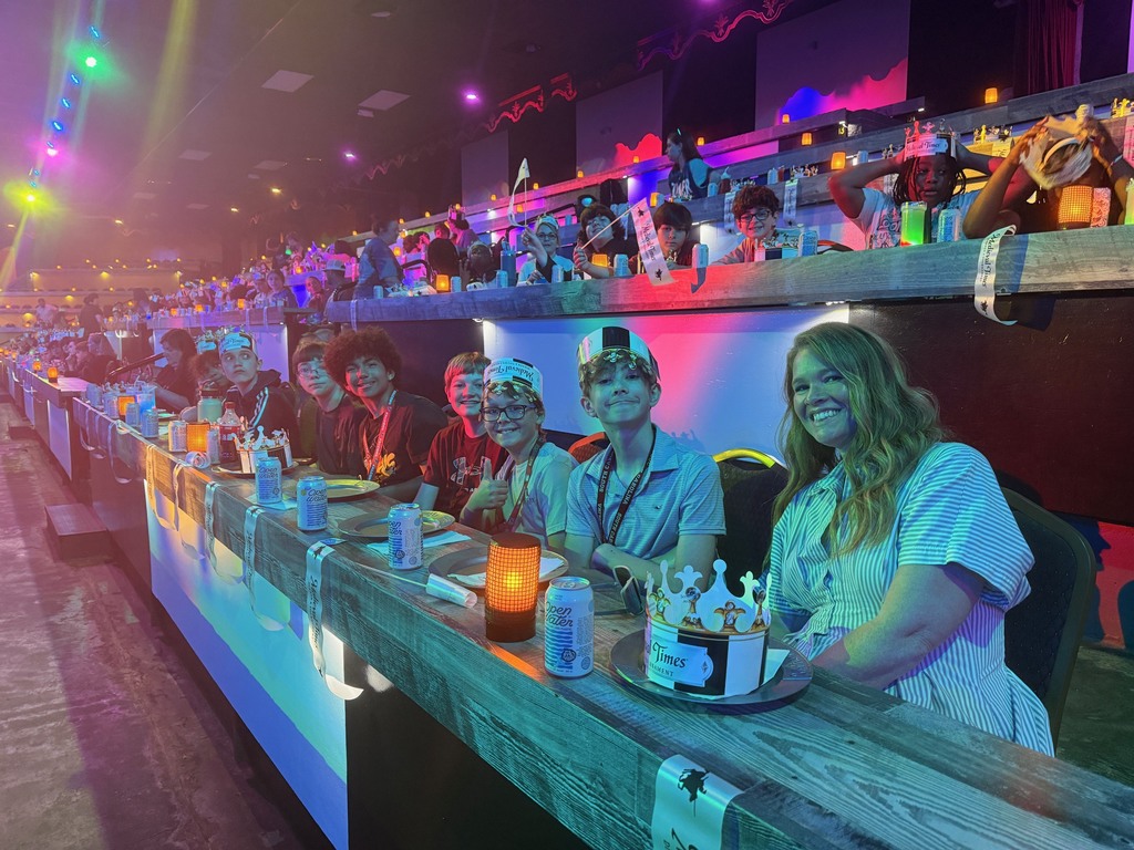 Students seated at tables waiting for the Medieval Times Show to begin.