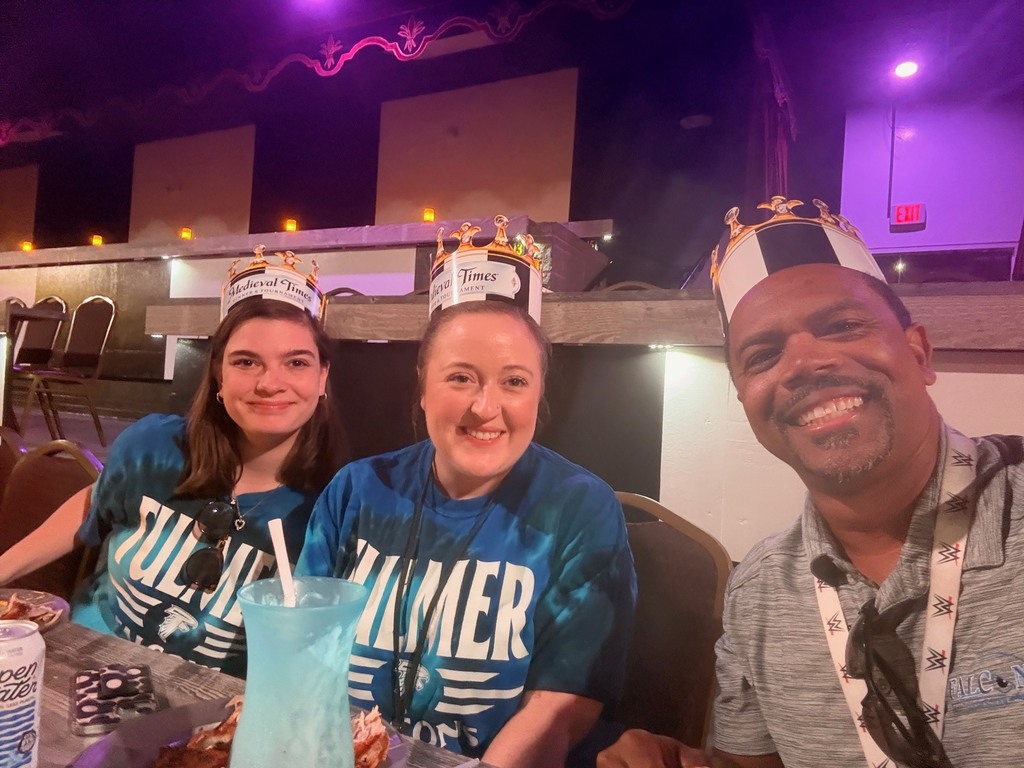 Three Fulmer teachers are seated at the table while enjoying food and watching the Medieval Times Show.