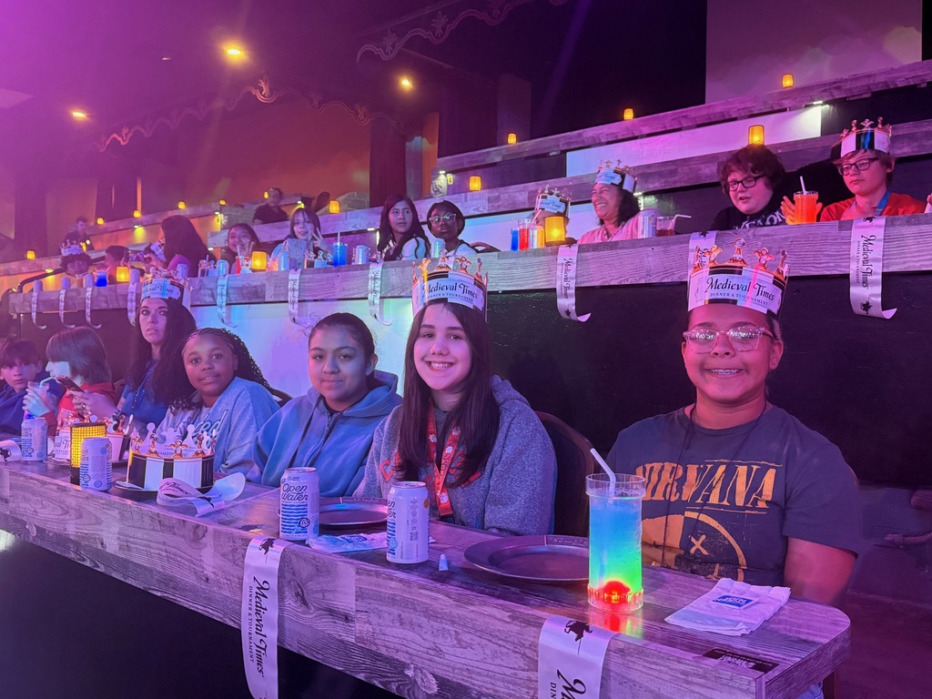 Students seated at tables waiting for the Medieval Times Show to begin.