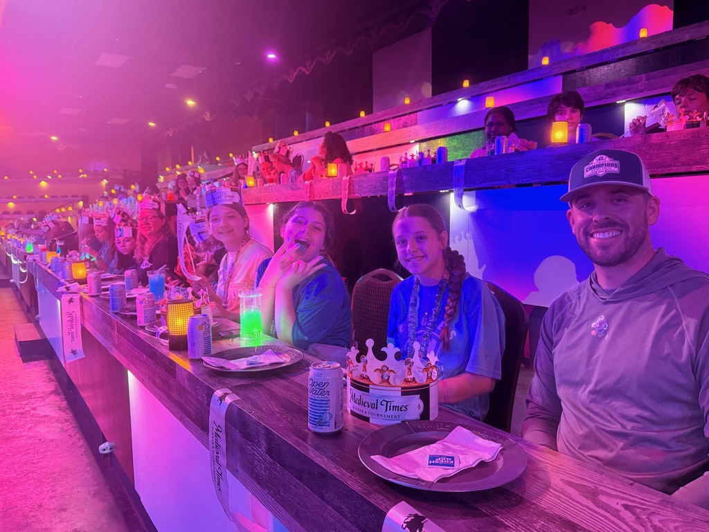 Students seated at tables waiting for the Medieval Times Show to begin.