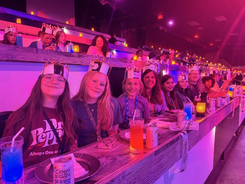 Students seated at tables waiting for the Medieval Times Show to begin.