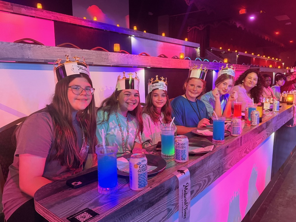 Students seated at tables waiting for the Medieval Times Show to begin.