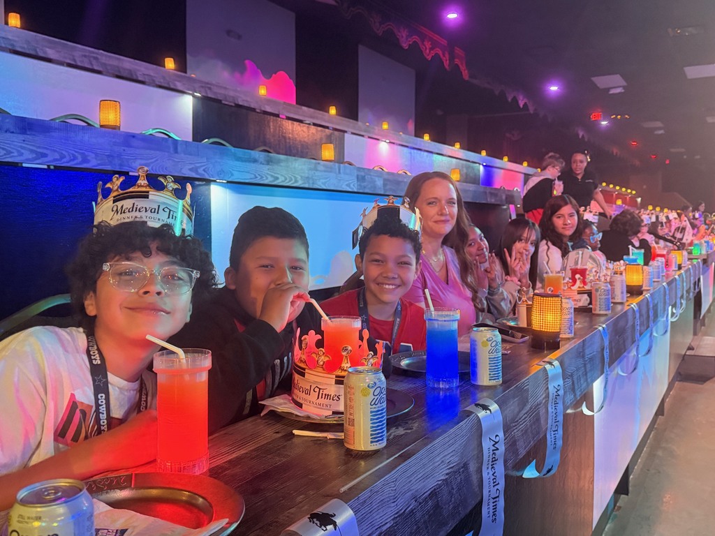 Students seated at tables waiting for the Medieval Times Show to begin.
