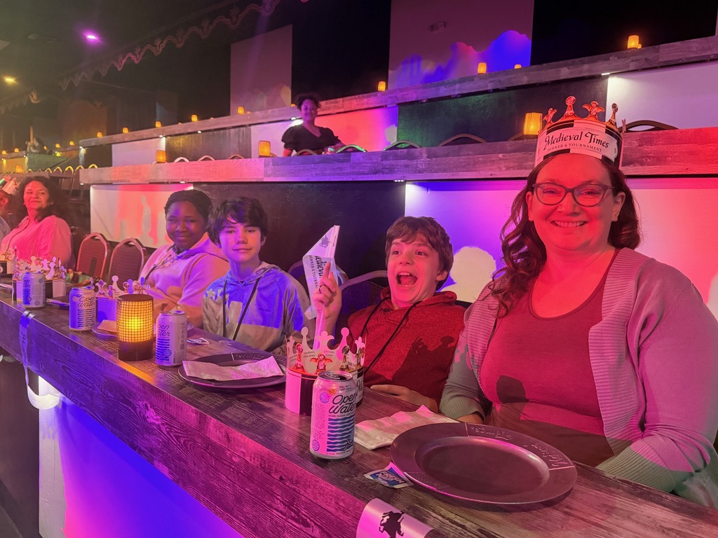 Students seated at tables waiting for the Medieval Times Show to begin.