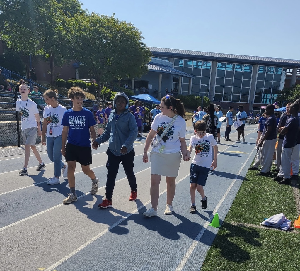 Students and adults walk side by side on the high school track.