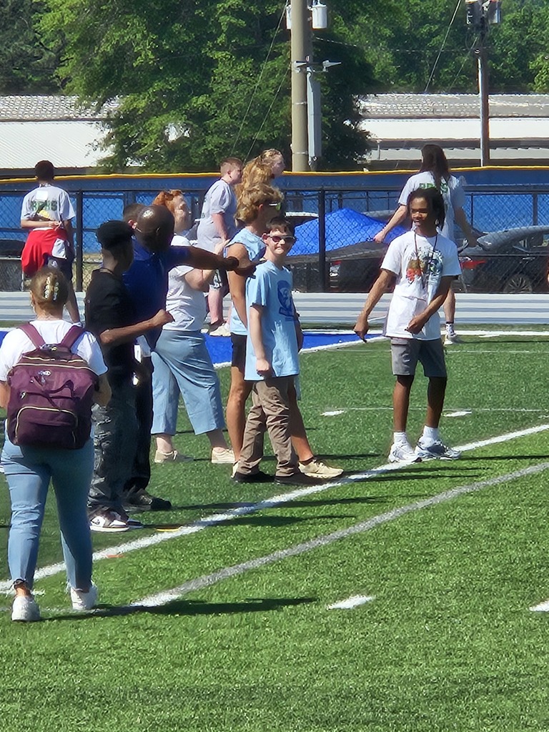 Students are lined up on the football field about to start a race as an Olympic event.