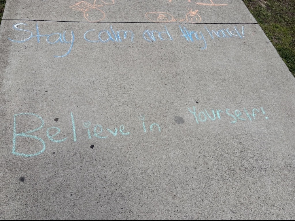 Sidewalk chalk states, "Stay calm and try hard!" and "Believe in Yourself!"