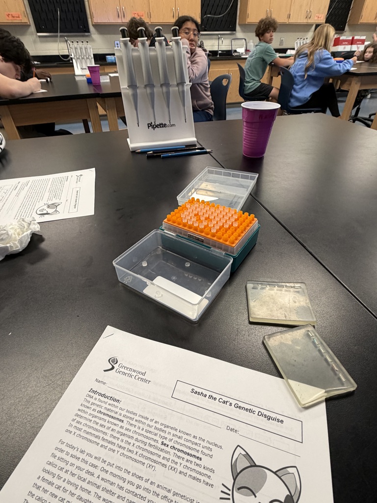 Lab supplies and a sheet of paper are on a science lab table. The paper is from the Greenwood Genetic Center and it is where students read information about the lab and record their findings.