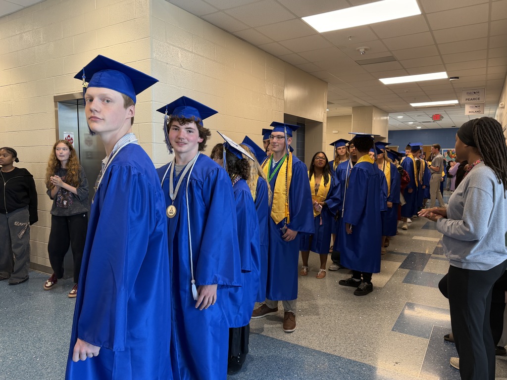 Seniors stand in the hallway awaiting the time to begin their senior walk through in their graduation regalia.