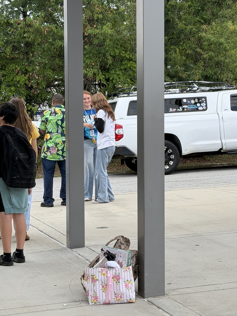 A teacher talks with a student before she gets into the car on the last day of school before summer.